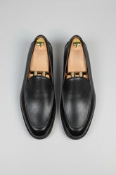 Black leather slip-on loafers with textured finish, perfect for formal or business casual wear.